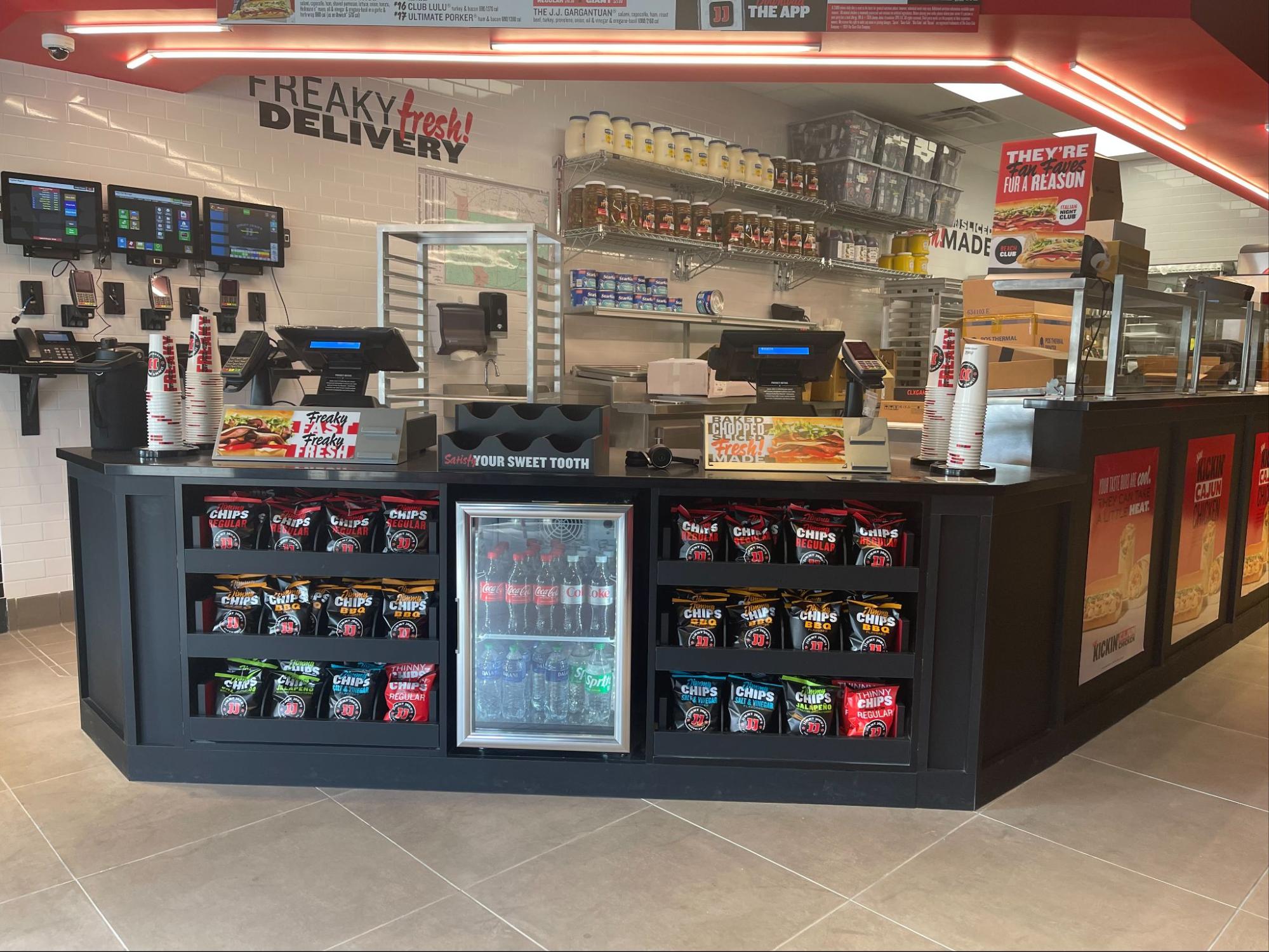 Jimmy John's Store counter with PDQ POS terminals, chips and drinks.